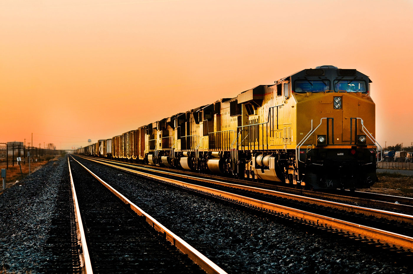 Acme OEM Transportation | Cargo locomotive railroad engine crossing the desert at sunset